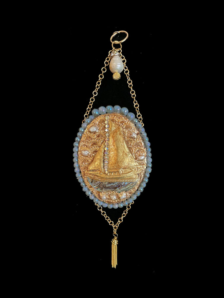 Sail away, sail away, sail away. Abalone, pearls, and iridescent beads surround this golden ship as it heads for the shores of dreams.