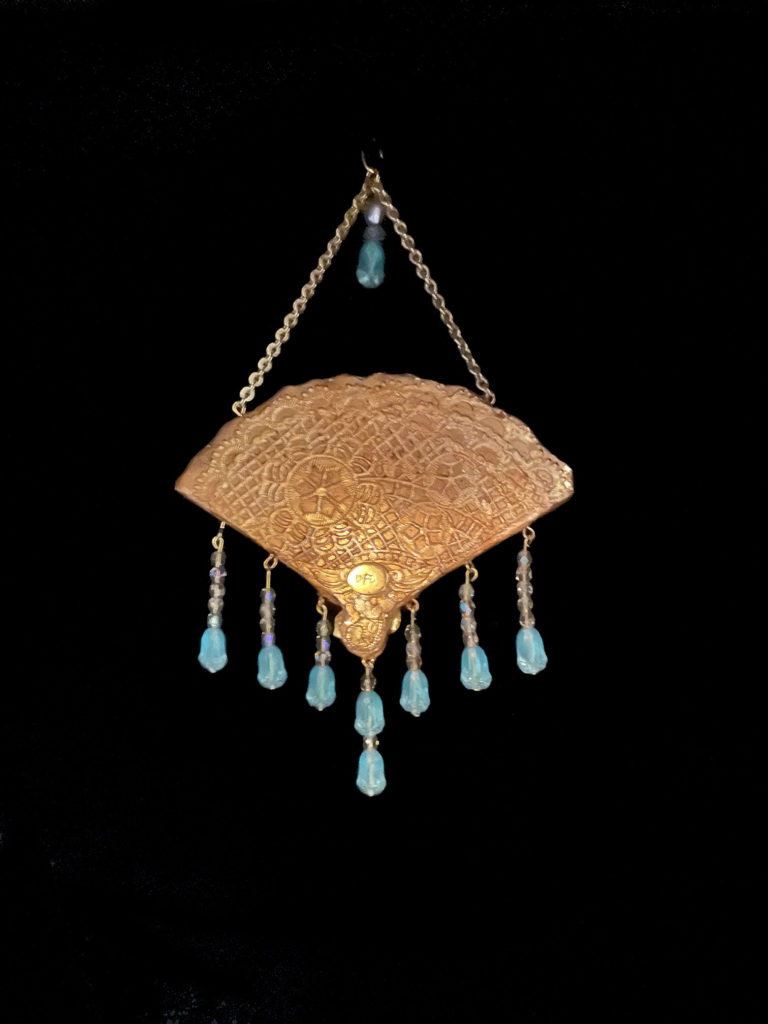 M’lady’s fan is enhanced with a blue intaglio cameo framed by pearls. Iridescent tulip-shaped beads fringe the pendant.