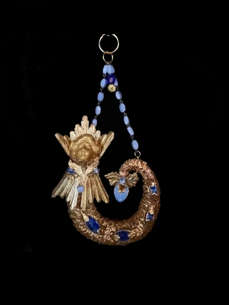 Wife of Poseidon she is adorned with Opalite and ocean blue stones. She is a truly royal merwoman.