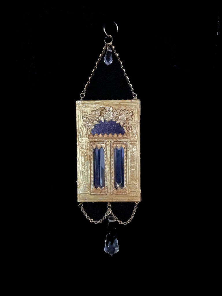 Peer into the heavens through the Blue Goldstone transom of this golden portal. Dangling crystals invite you to knock.