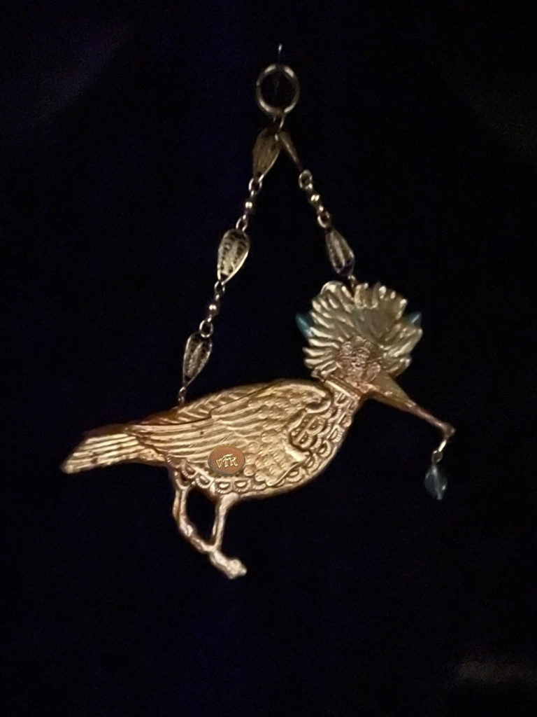 With her iridescent feather crown, Queen Hoopoe rules her domain. Her body sparkles with a titanium coated sugar crystal Druzy and a small glass bead dangles from her long beak.