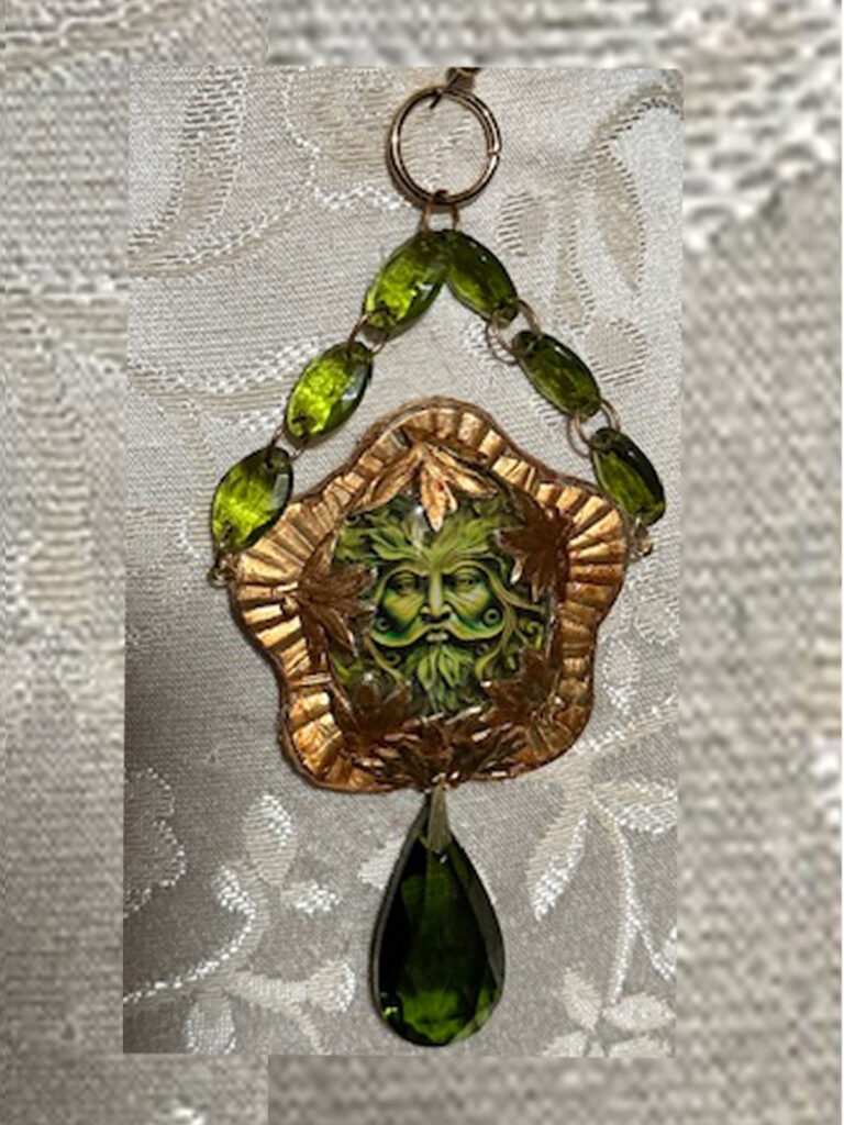 Pendant with gold color, face of Father Earth and Green Crystals