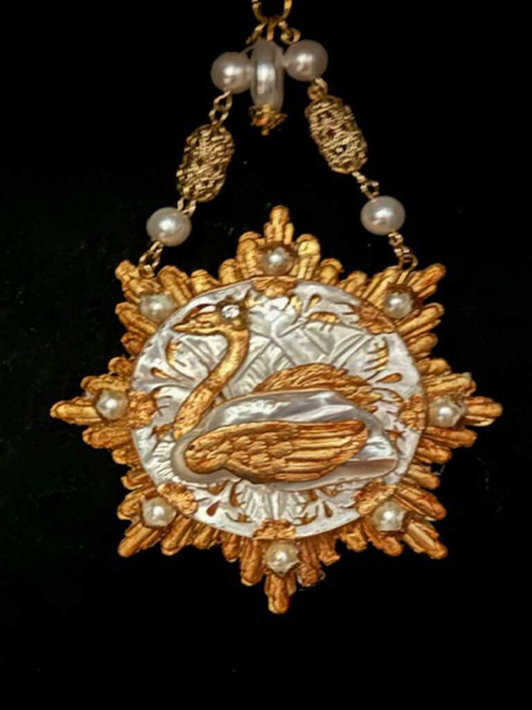 Gold colored pendant with a Baroque Pearl containing a gold swan