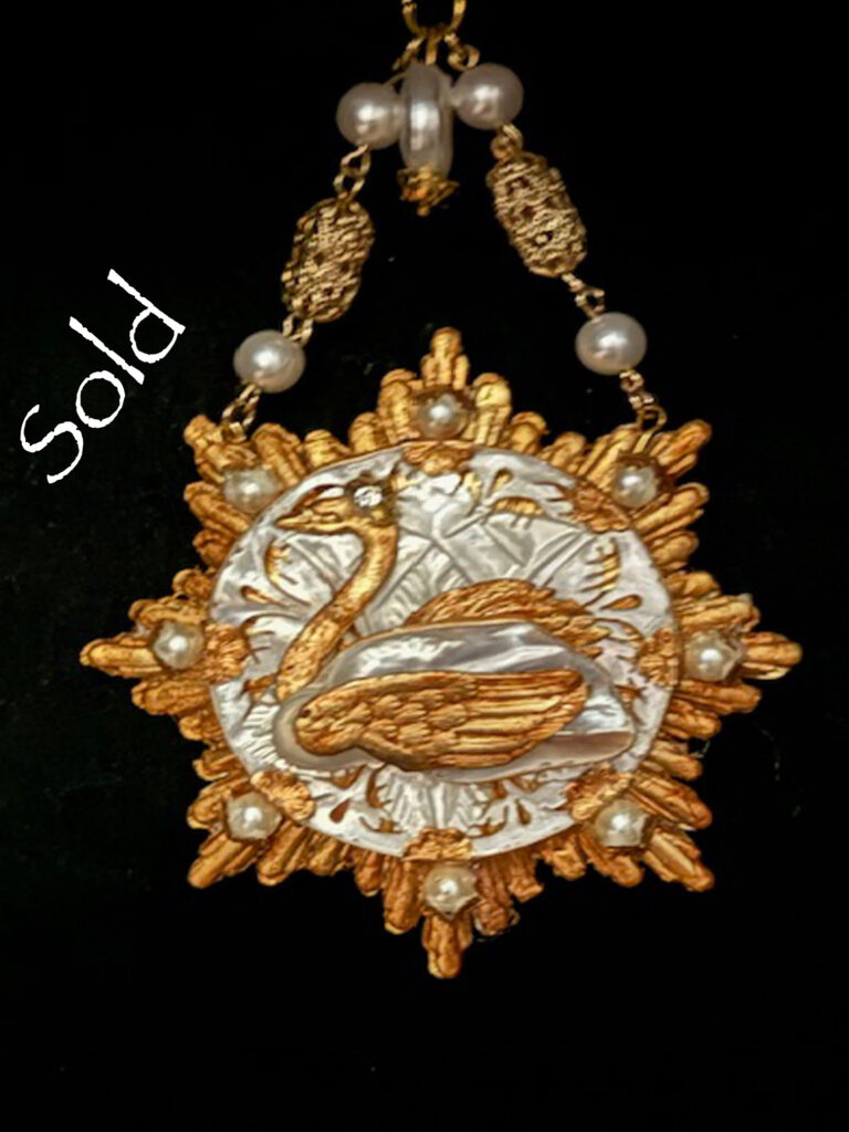 Gold colored pendant with a Baroque Pearl containing a gold swan